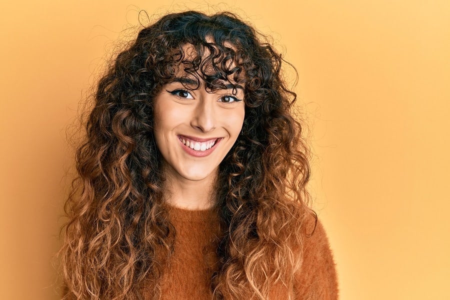 long curly shag with dark roots, ombre ends, and curly fringe
