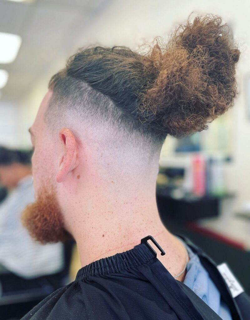 long curly topknot with bald fade