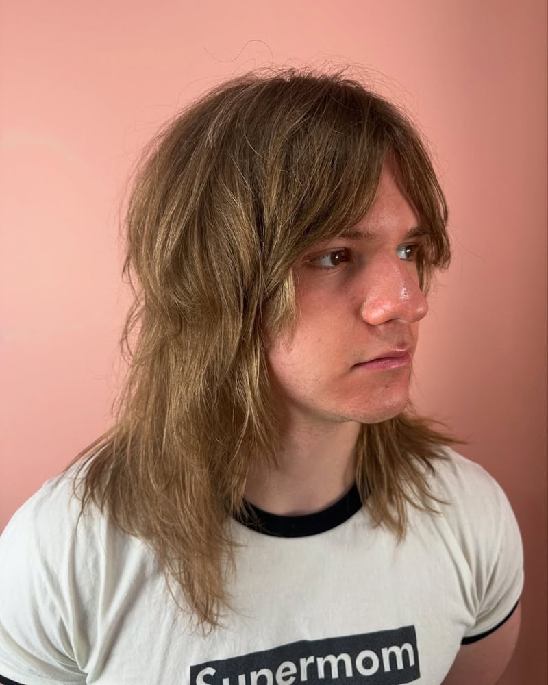 boy with a light brown, long shaggy wolf cut