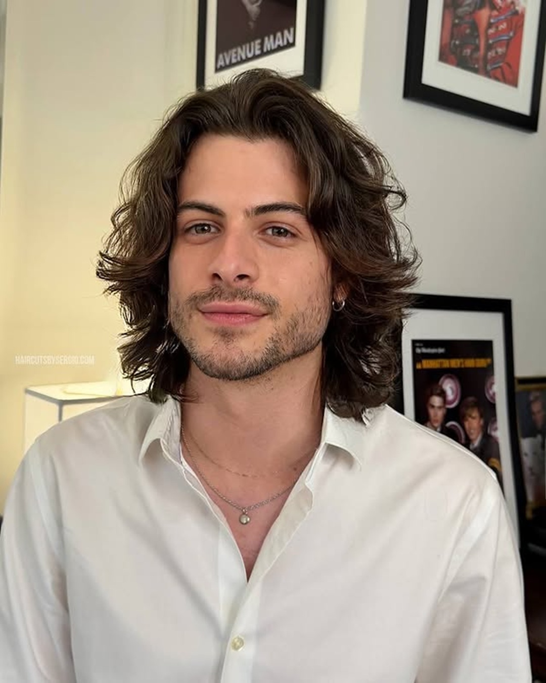 wavy long layered hairstyle for men with a widow's peak and middle part