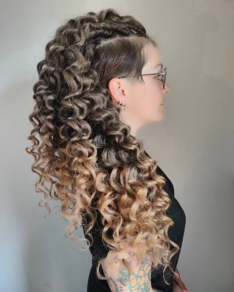 Curly long mohawk with braided top, shaved side, and cascading ombr&eacute; ringlets.
