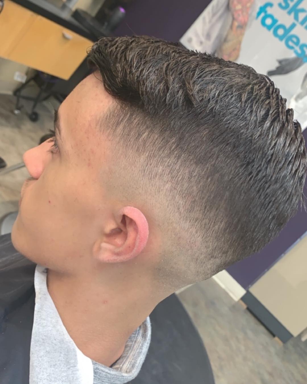 Man with a low skin fade and textured side-swept comb over haircut