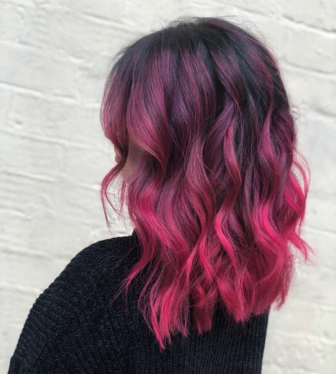 Wavy long bob haircut featuring dark-to-magenta pink balayage highlights