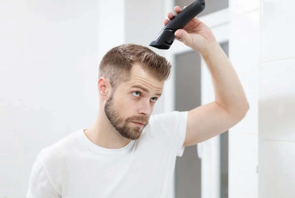 man cutting top hair with clipper