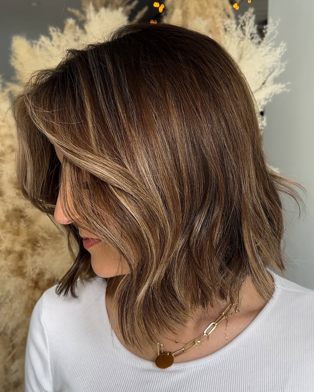 wavy medium brown lob and face framing caramel blonde highlights