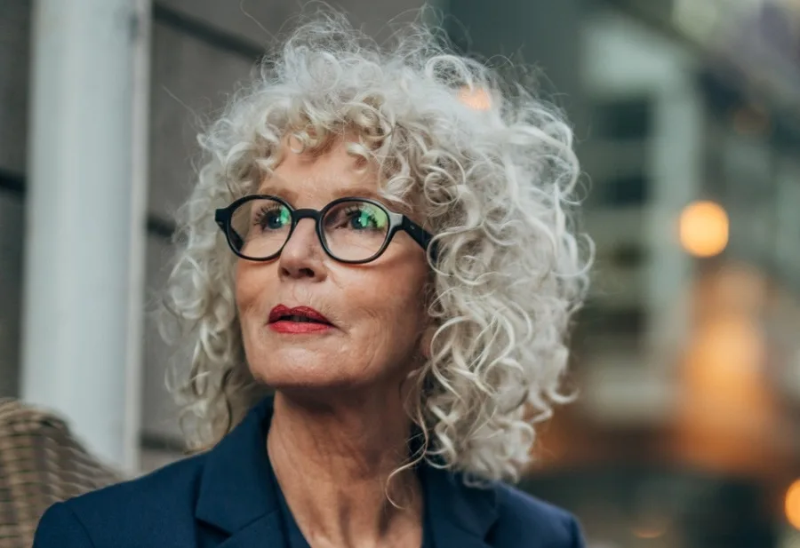 medium curly perm hairstyle for over 60 with glasses