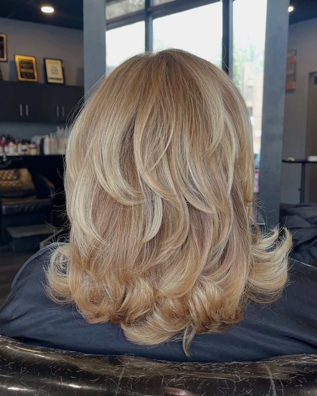 medium length blonde hair cut with short feathered layers and flipped ends