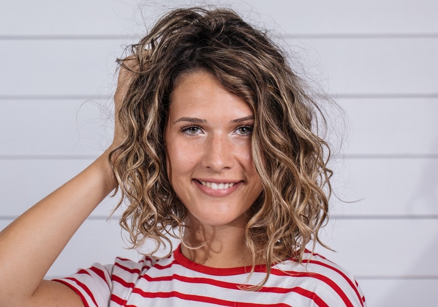 Medium length curly hairstyle for women with a heart face
