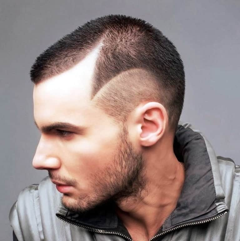 Short buzz cut with a sharp shaved line design drawing focus from a receding front hairline