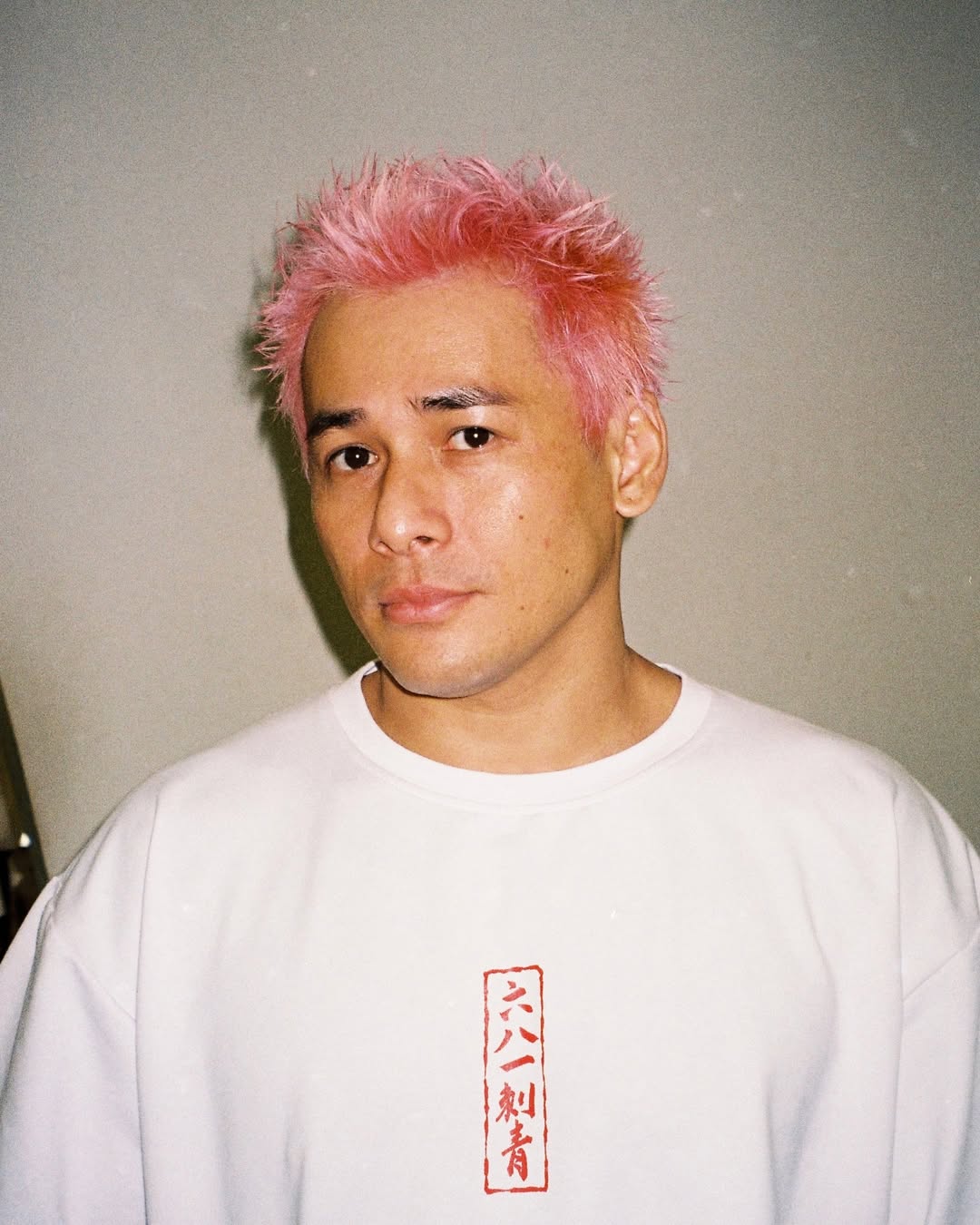 pink short spiky hairstyle for men with a widow's peak