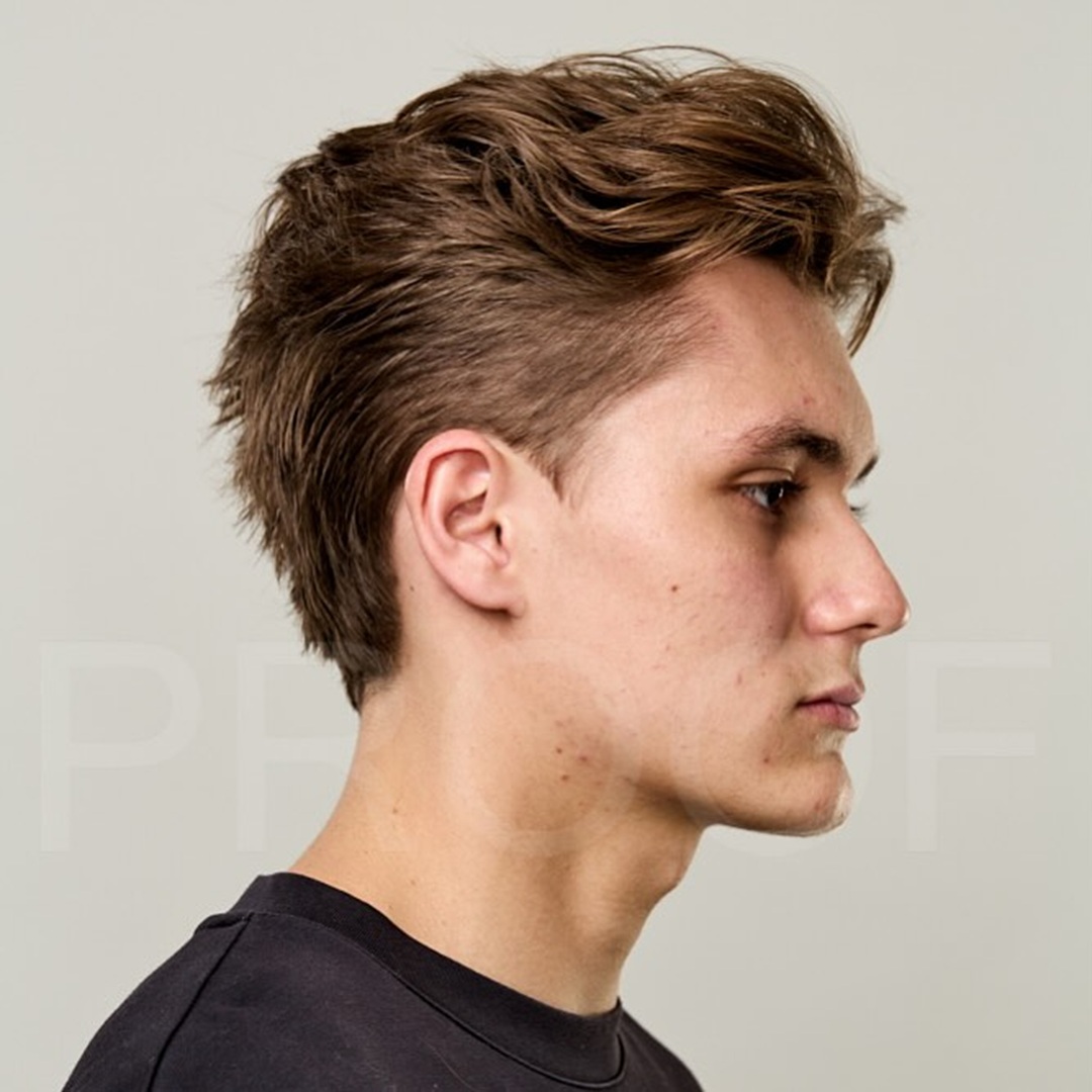 Man with a textured light brown wavy messy pompadour hairstyle