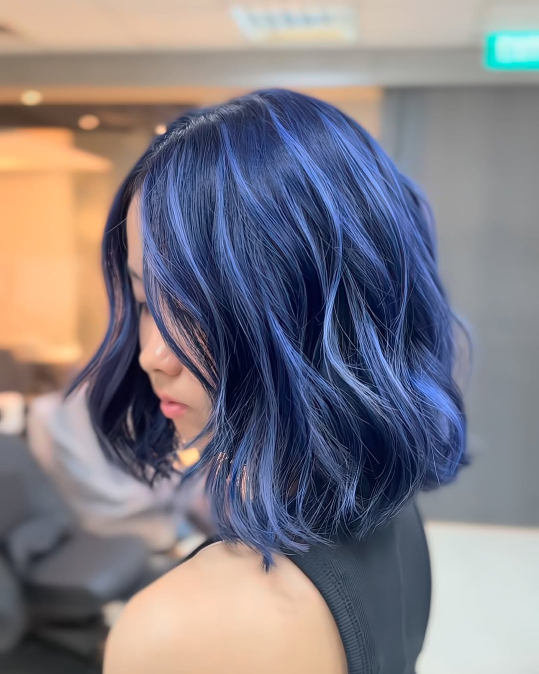 Wavy dark shoulder length lob with vibrant midnight blue highlights on Asian hair