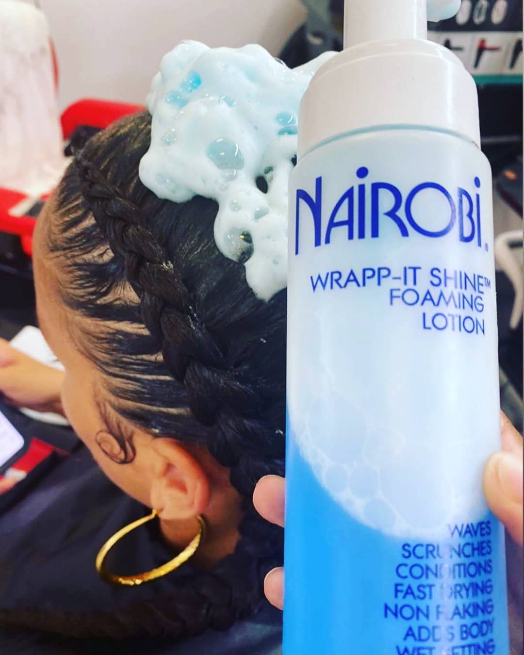 Stylist applying Nairobi Wrapp-It Shine to set braided strands, demonstrating the best setting foam for natural hair