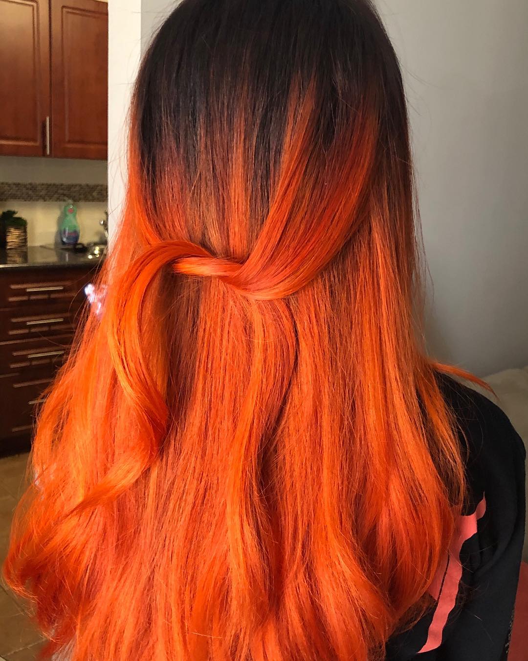 Long half-up hair featuring a high-contrast neon orange ombre