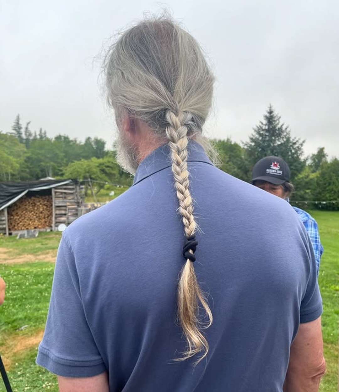 Older man with long silver hair styled into a neat low braid