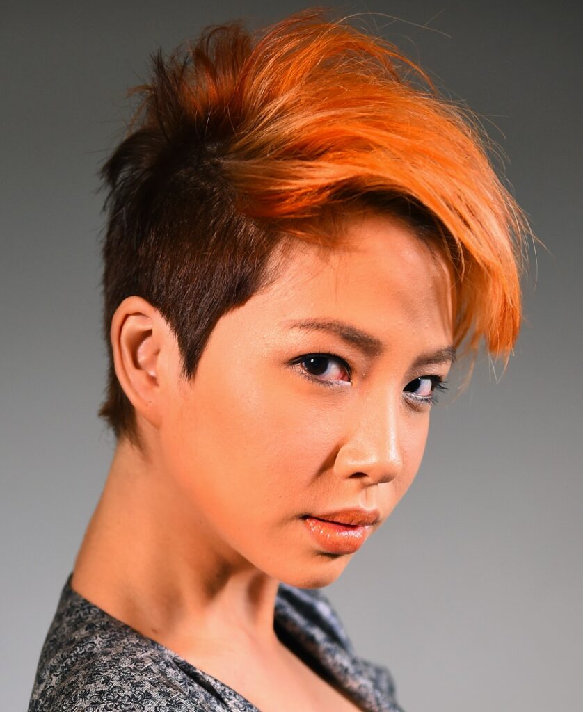 Orange hair color matches olive skin and brown eyes