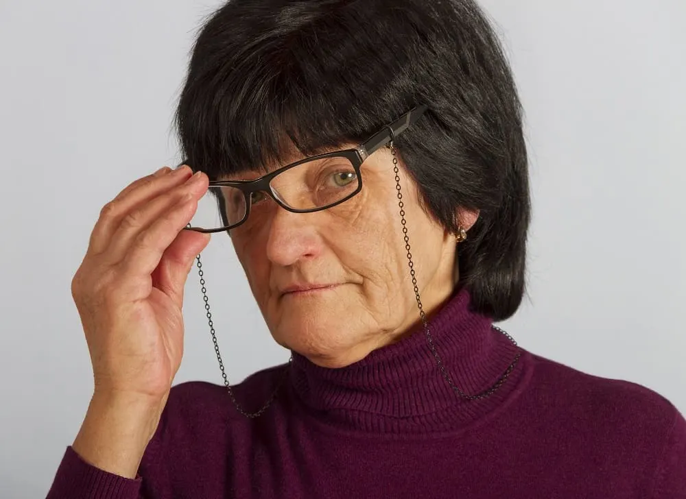 over 60 woman with black hair and glasses