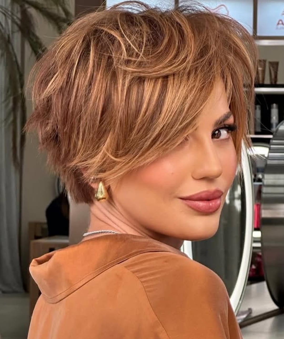 textured warm blonde pixie cut with long side swept bangs