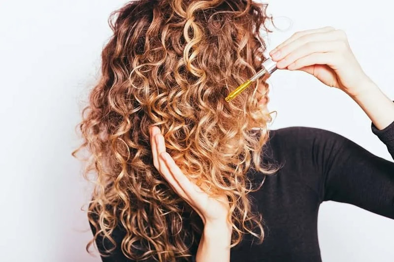 Applying pre-shampoo oil to curly, multi-textured hair