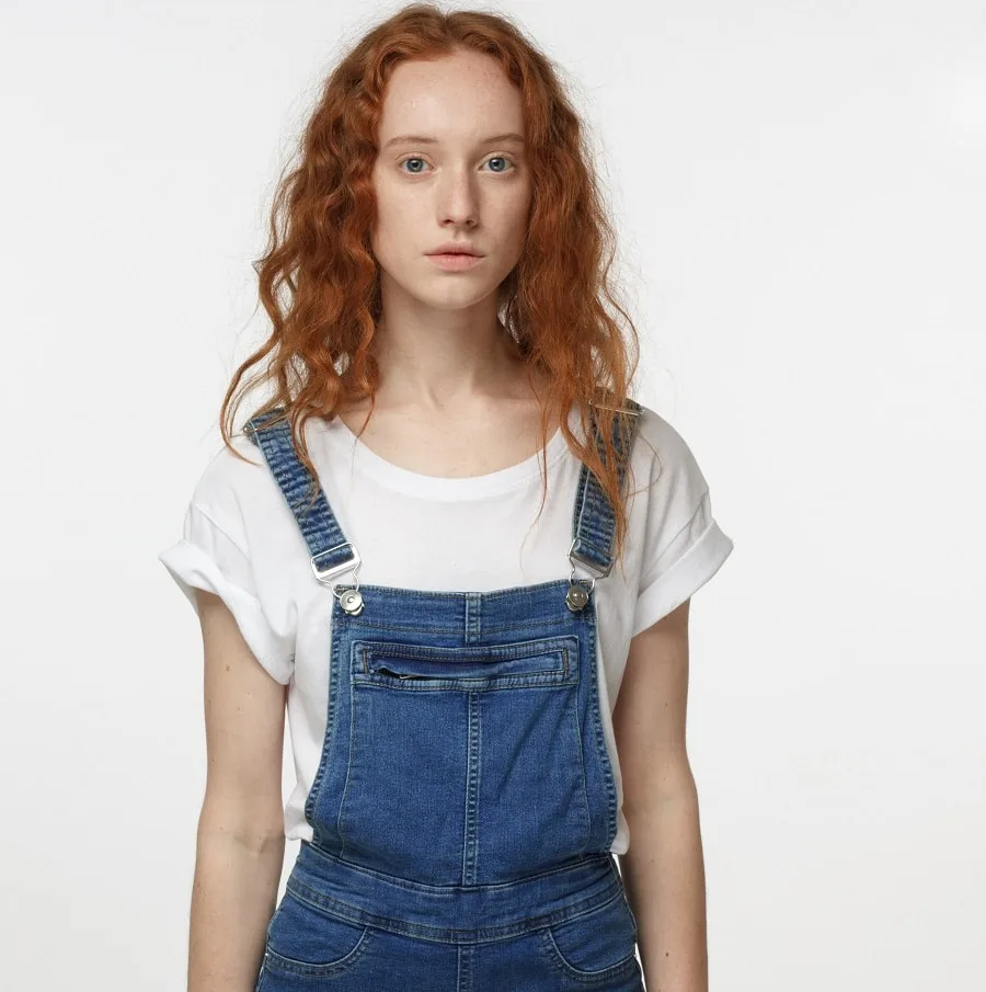 red curly hairstyle for denim jumpsuit