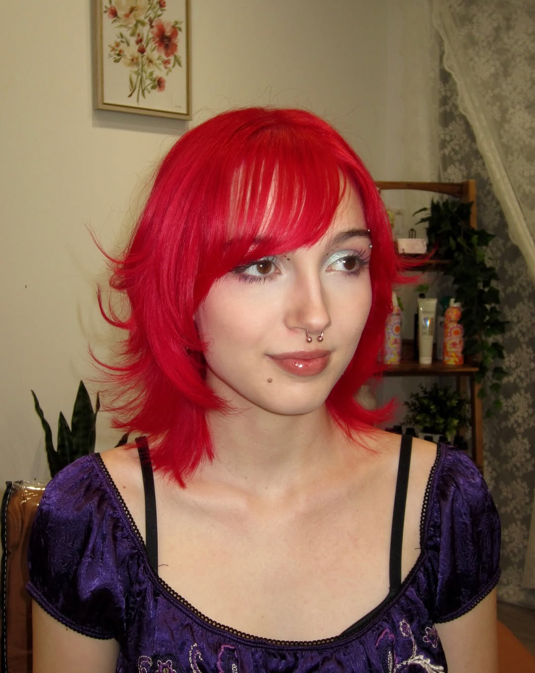 Bright red short shag haircut featuring wispy side-swept bangs