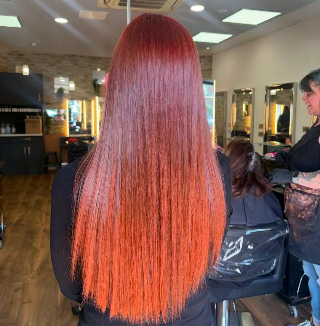 Long straight hair with a seamless red to fiery orange ombre melt