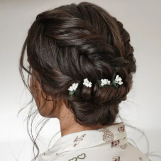 Reverse fishtail braid with bun tutorial: back view of the finished low bun trimmed with baby’s breath flowers