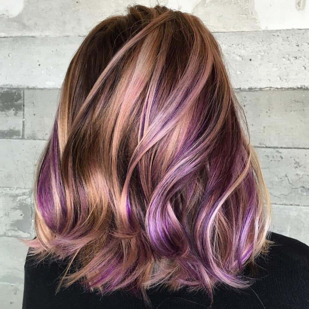 Rose gold blonde lob with soft waves and vibrant purple peekaboo highlights underneath