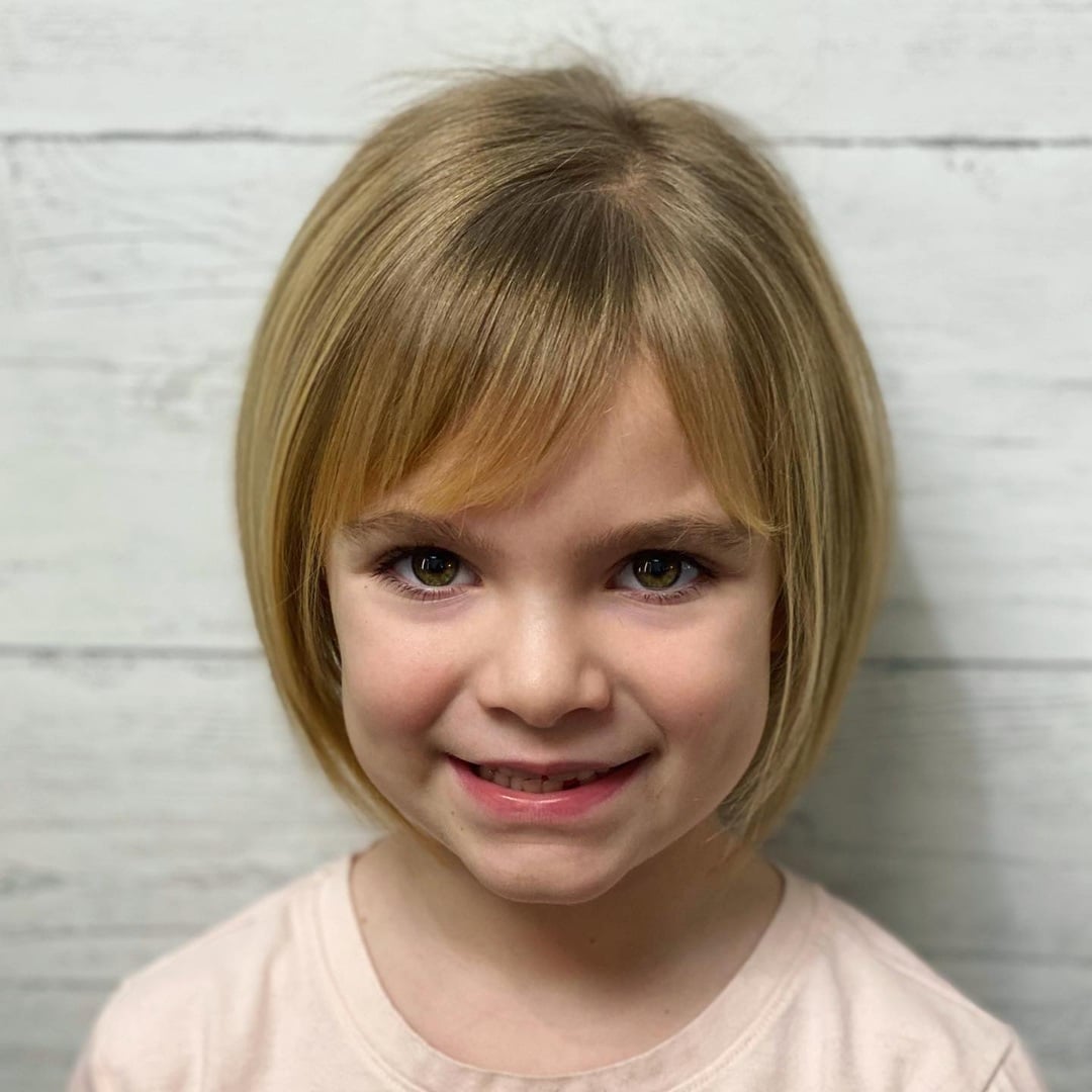 little girl straight blonde short rounded bob haircut and soft side-swept bangs
