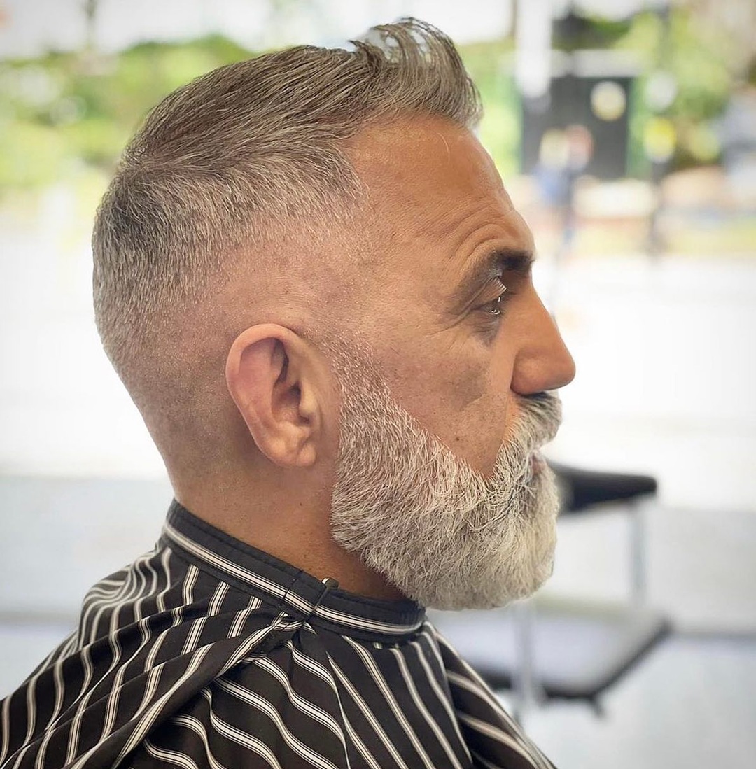 older man with short gray brushed up hair featuring a high fade