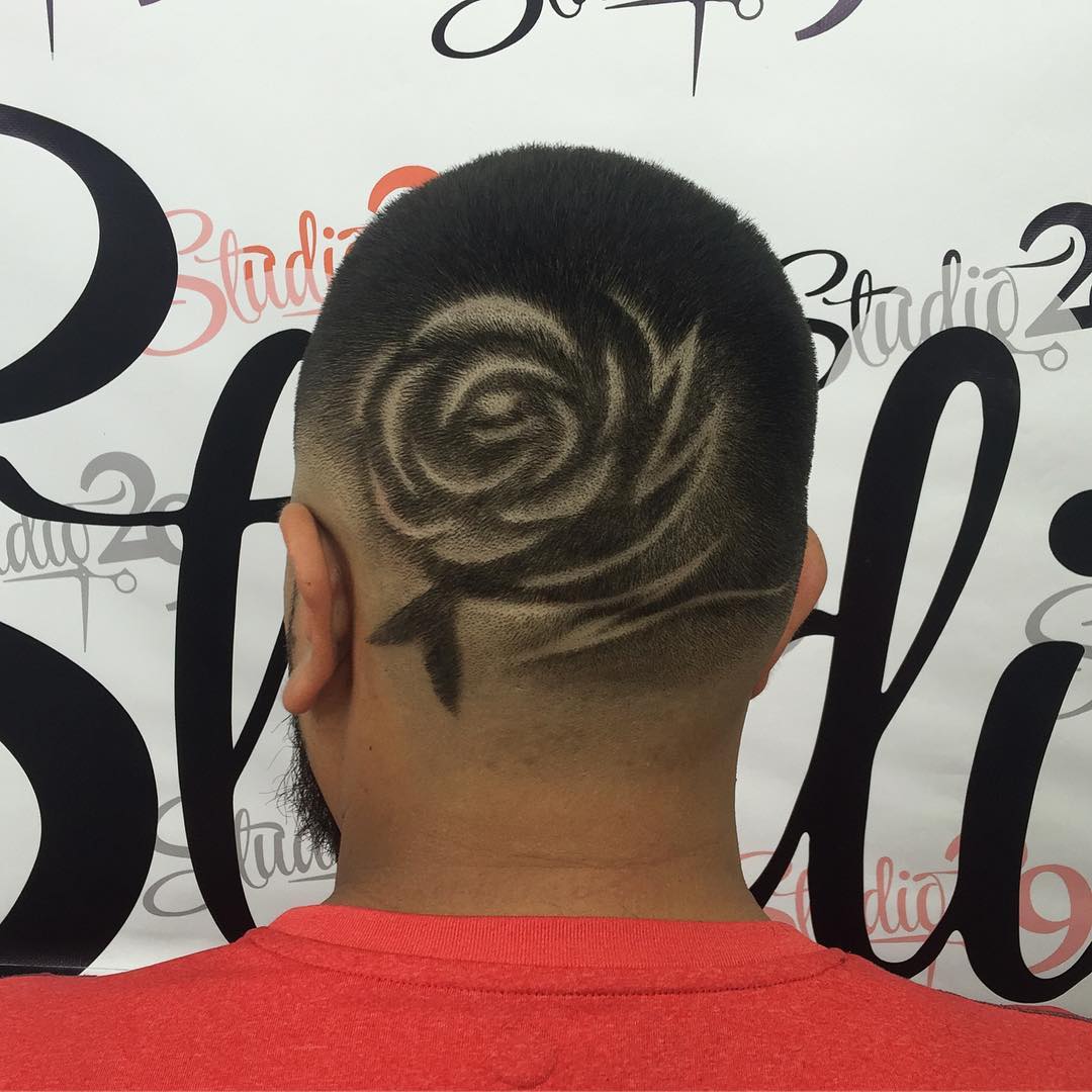 back view of a black man featuring short buzz cut fade featuring an intricate rose hair design