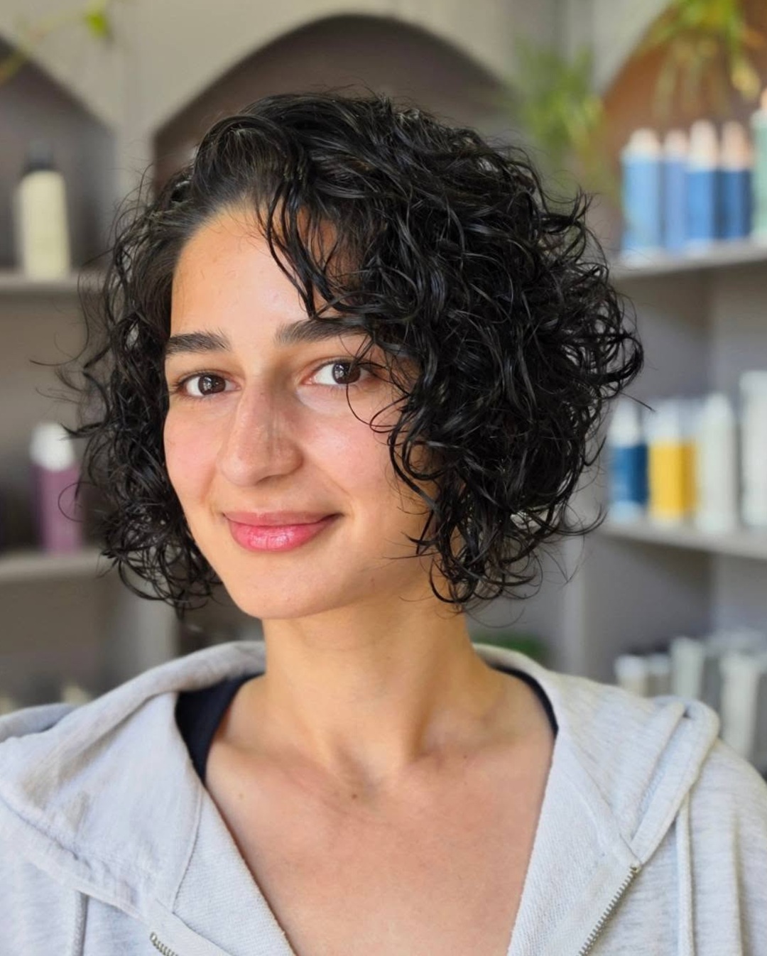 short dark brown curly bob haircut with side bangs