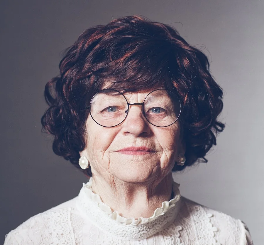 short curly hairstyle for over 70 with glasses