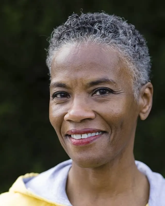 older woman with short gray afro hair