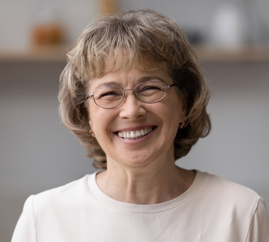 short hairstyle for round faced women over 50 with glasses