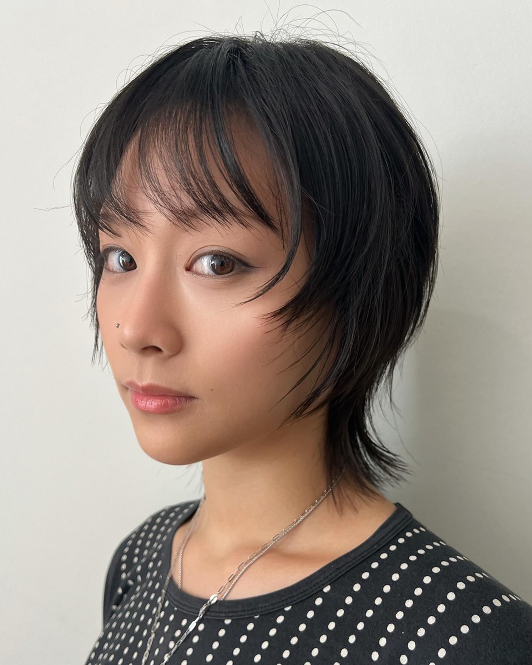 short dark wolf cut haircut with face framing layers