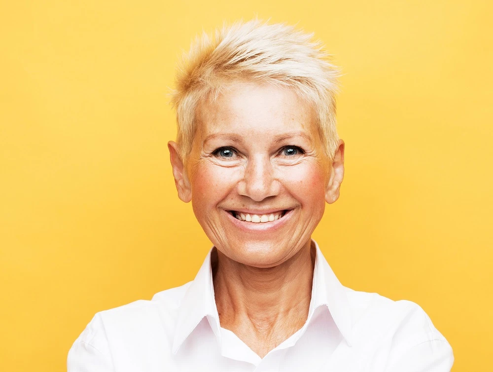 Short spiky hairstyle over 50 with a round face