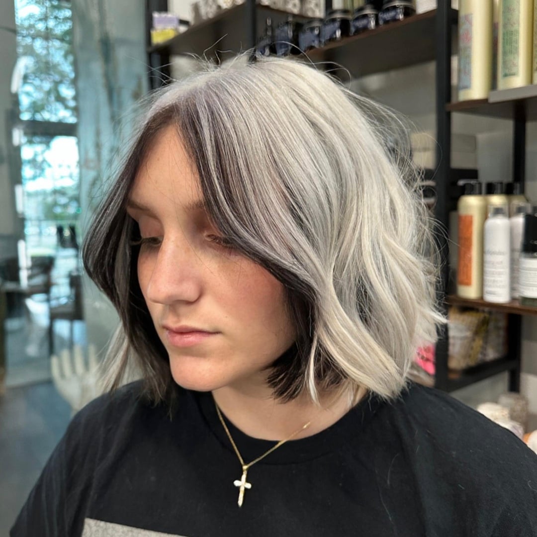 Wavy short white hair bob with dark face-framing peekaboo highlights