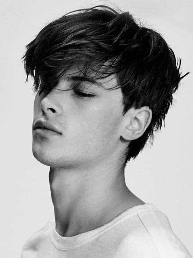 Young man featuring a messy side-swept haircut with bangs covering a receding forehead hairline