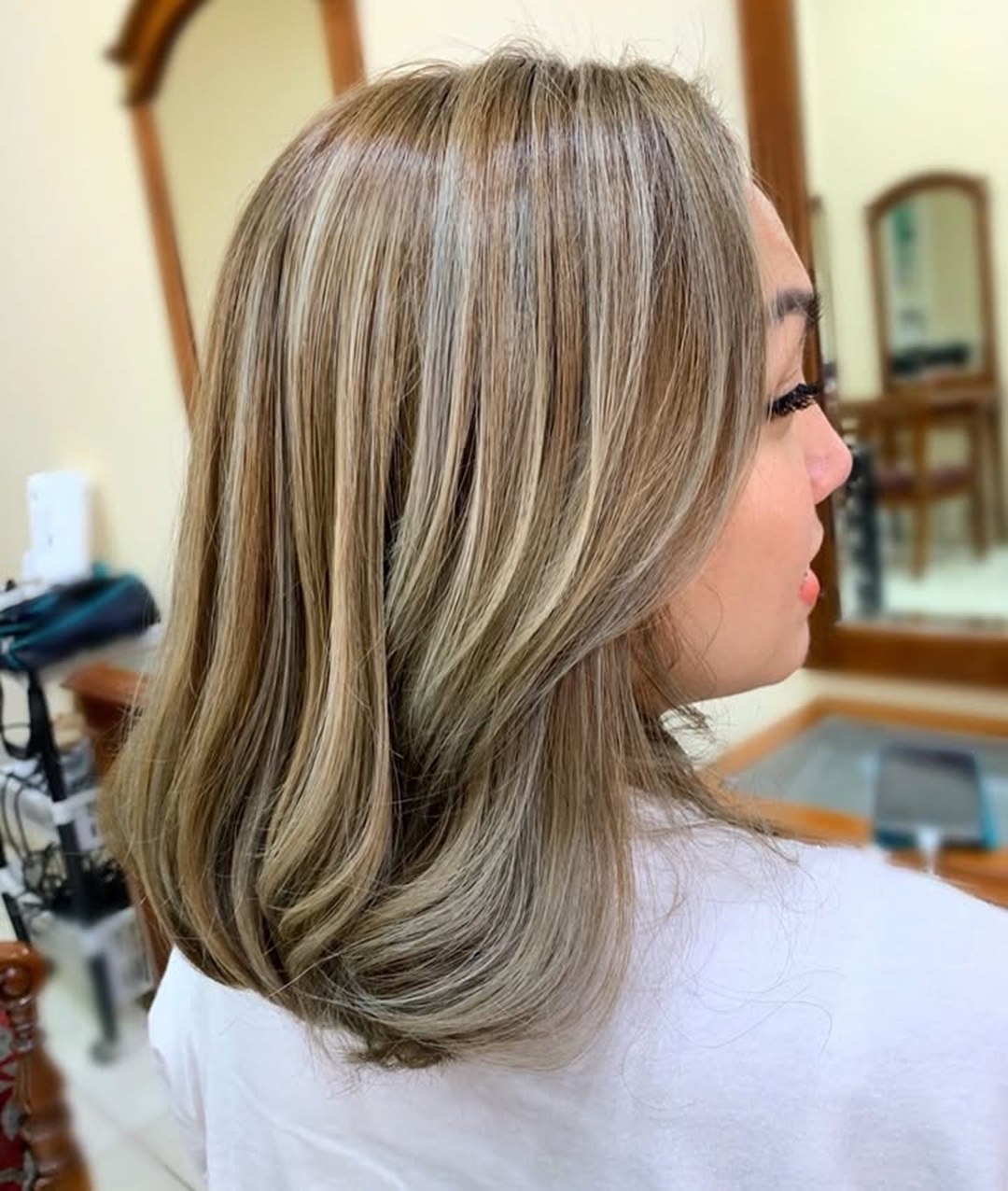 Woman with a golden brown lob featuring fine silver highlights
