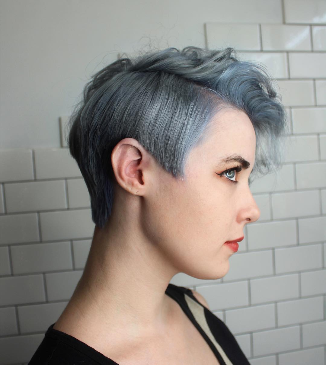 Icy silver blue asymmetrical pixie cut with wavy top volume and tapered sides