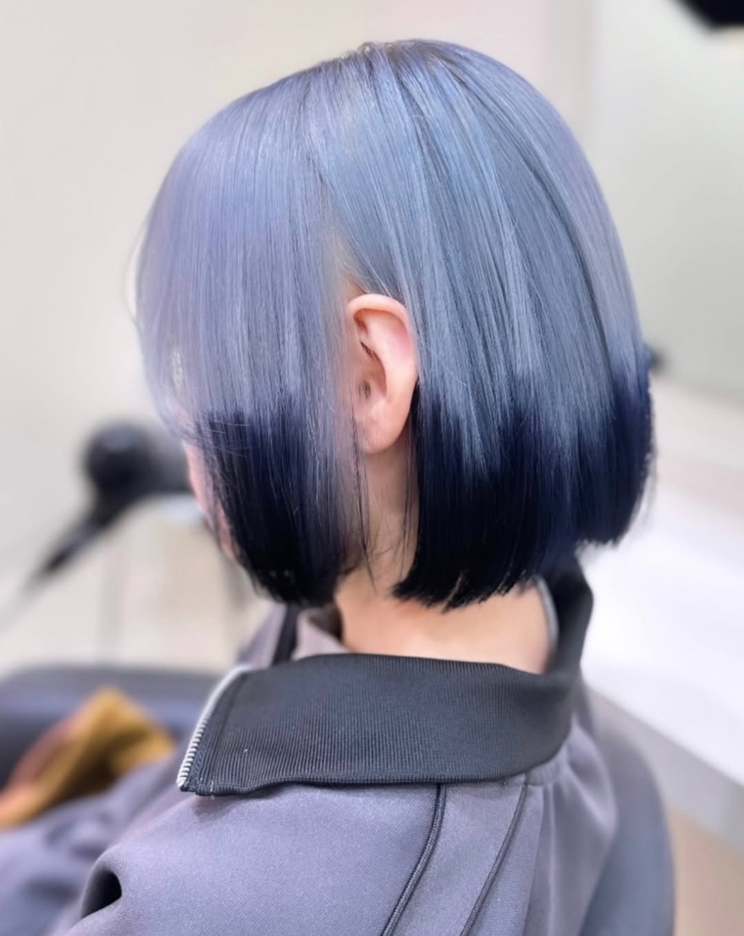 Sleek blunt bob featuring a silver blue hair color with dark navy dip-dyed ends