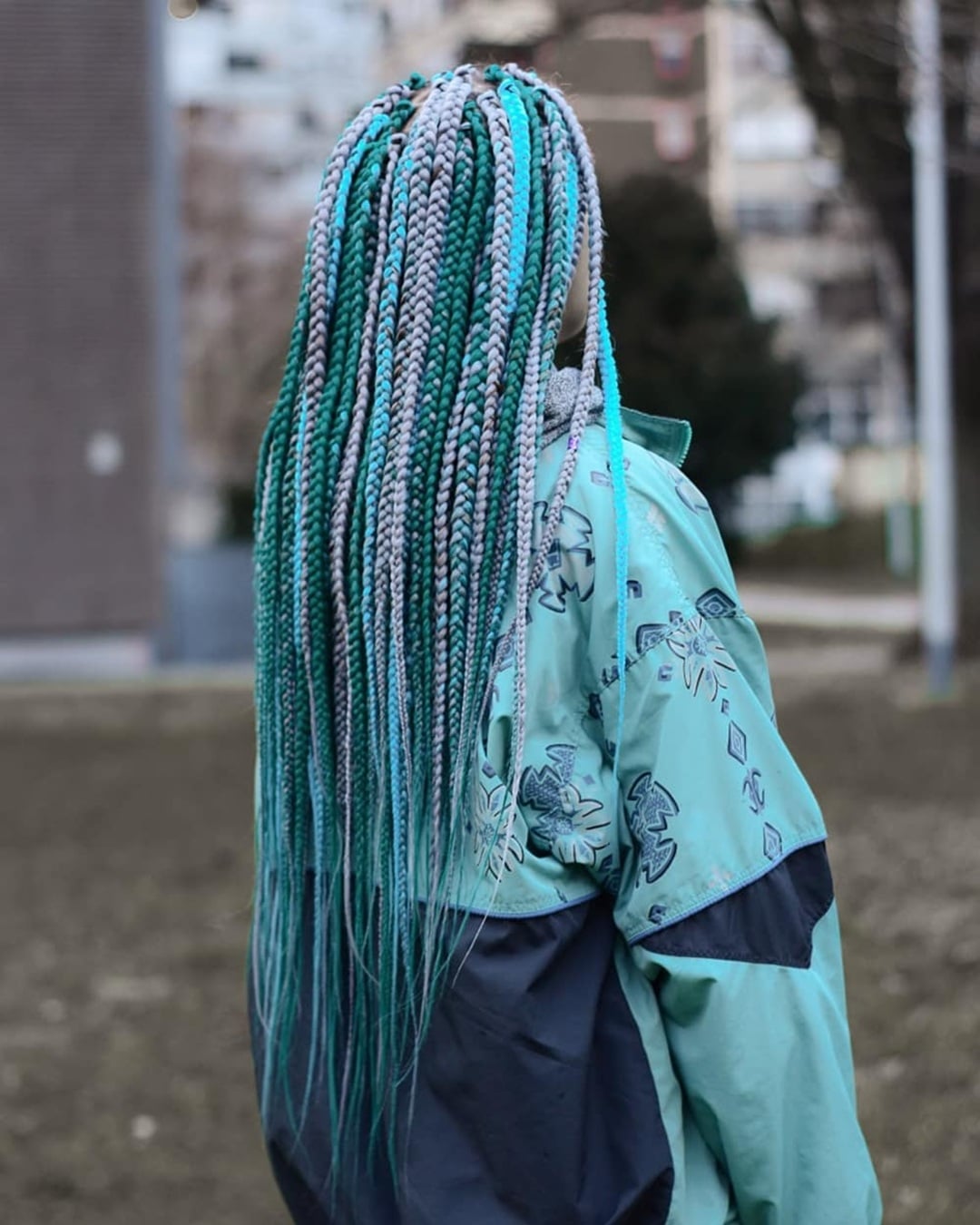 Long box braids featuring a vibrant mix of silver-grey, teal green, and bright turquoise strands