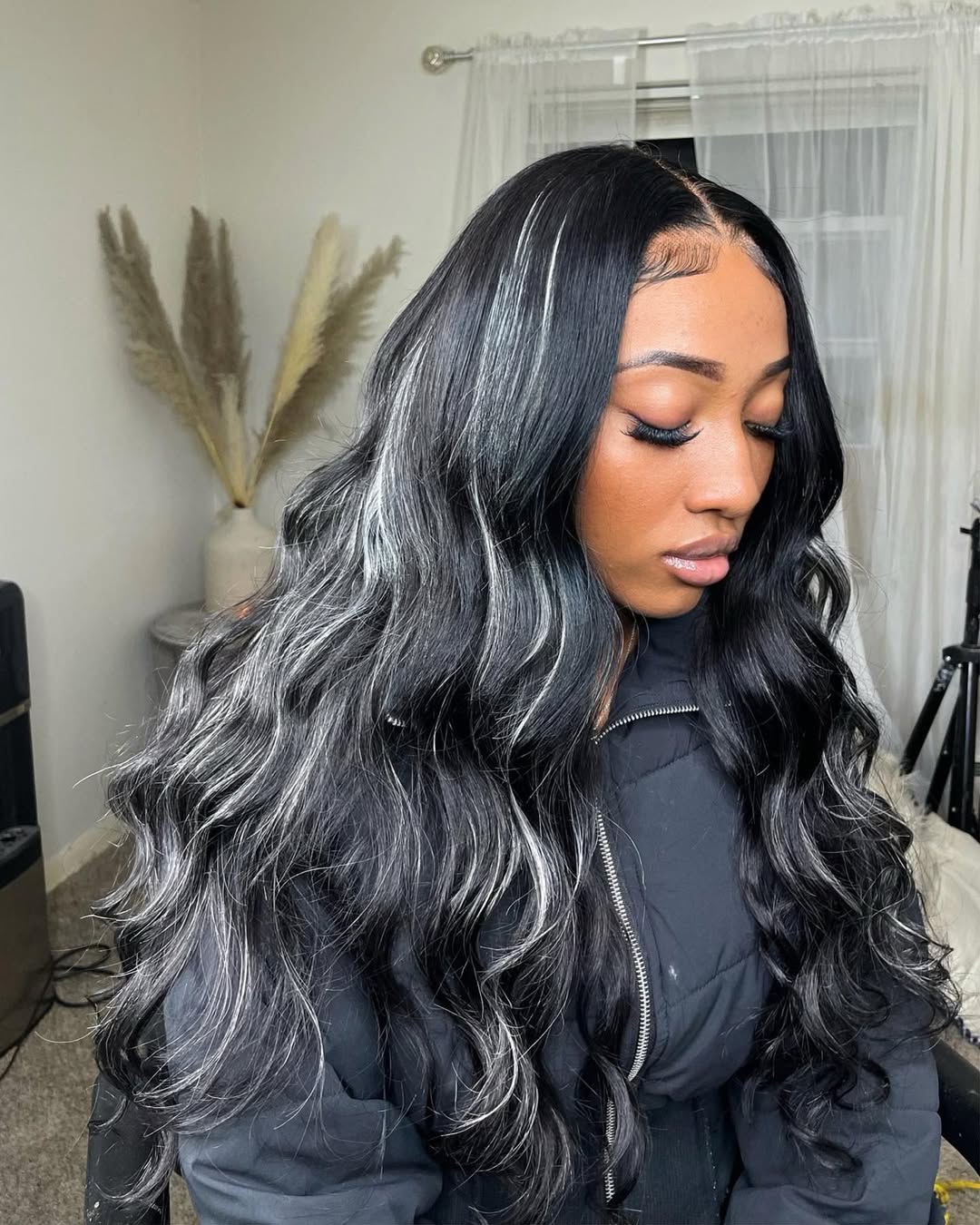 Woman with long wavy black hair and bright silver ribbon highlights