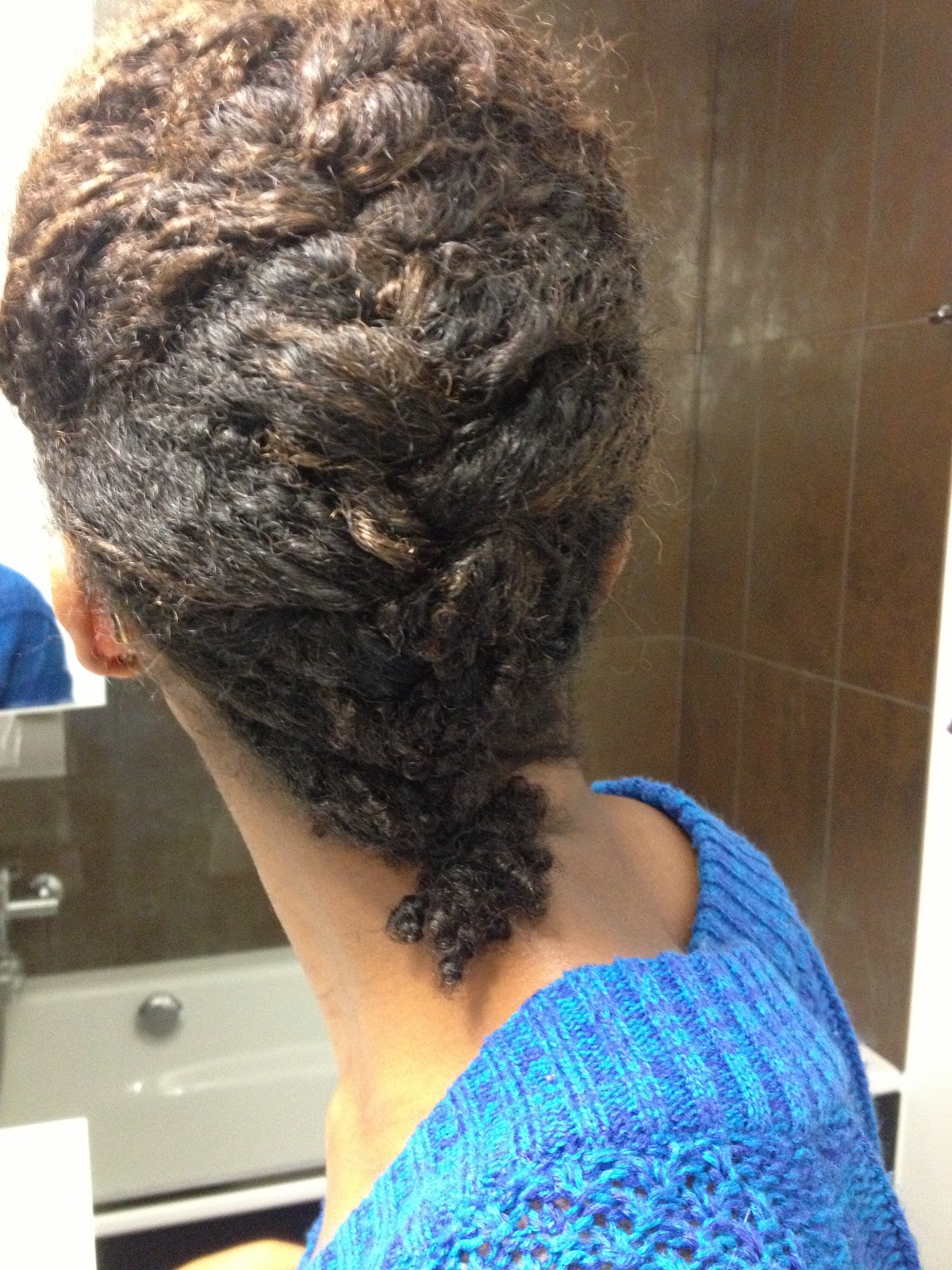 Single broad French braid down the back of the head, ending in a short textured tail.
