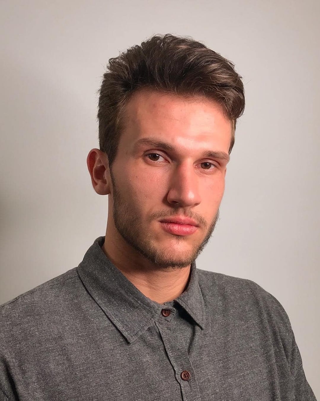 Men's skater haircut featuring a soft pompadour top with natural volume