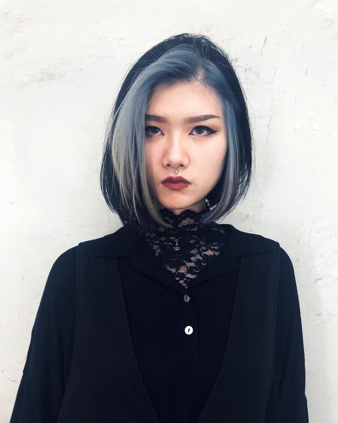 sleek chin-length black gothic bob haircut with silver face-framing highlights and a deep side part