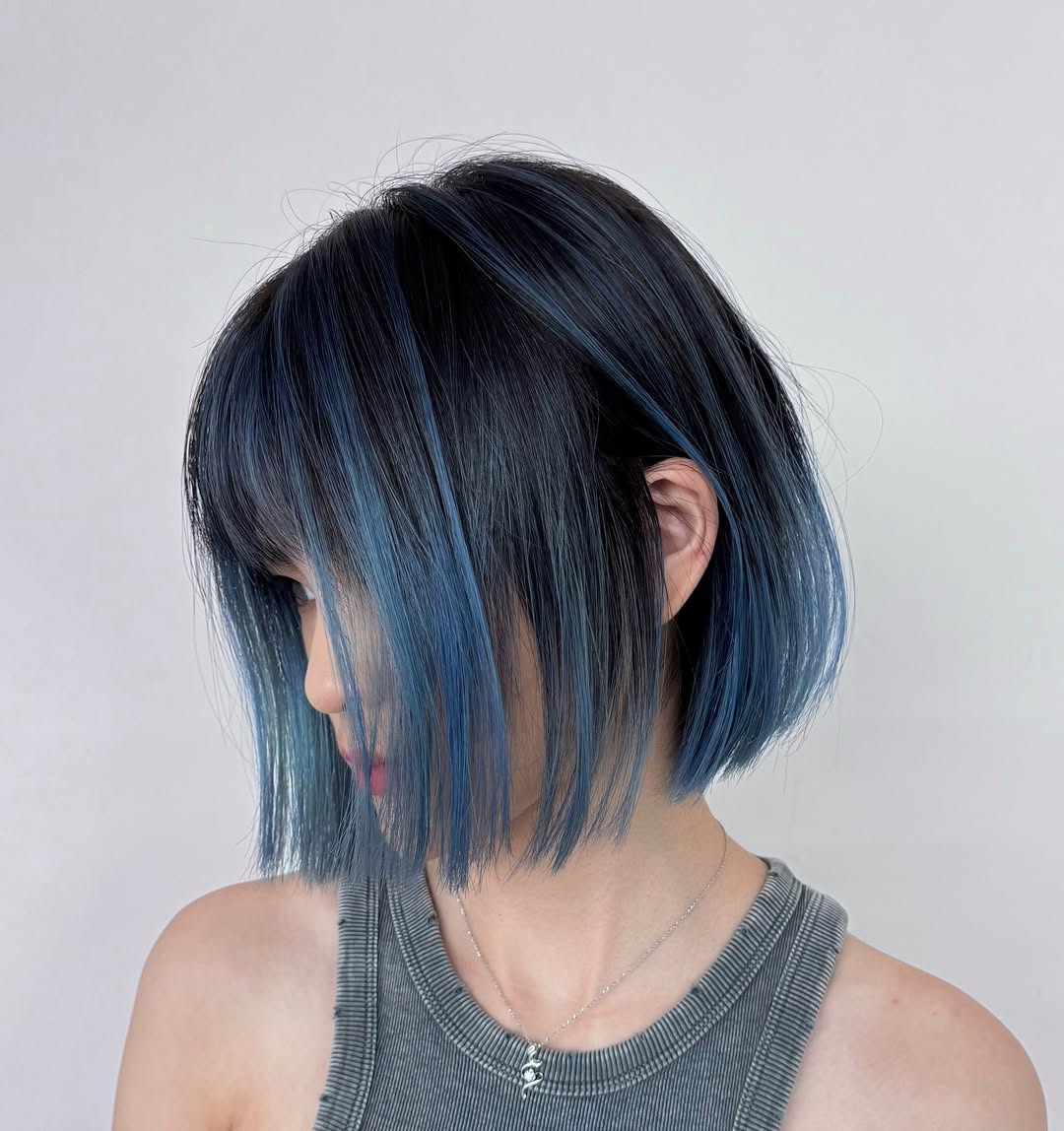 Sleek straight chin length balayage bob with smoky blue highlights and airy bangs