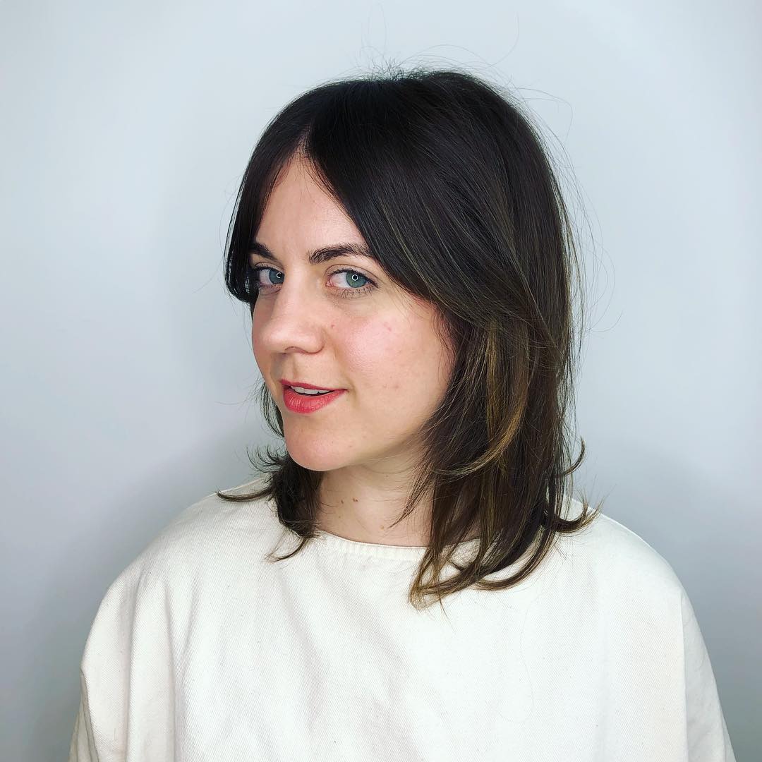 brown layered lob featuring soft middle-part curtain bangs and subtle highlights