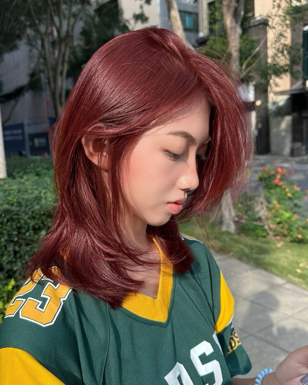 Woman with shoulder-length soft red wine hair featuring face-framing layers